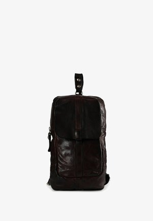 Sac à dos en cuir marron foncé avec rabat avant, poignée supérieure et fermeture éclair latérale. Surface texturée avec accents lisses et ferrures argentées.