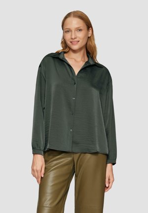 Donkergroene button-up shirt van gladde stof, met een kraag, lange mouwen en een relaxte pasvorm, gecombineerd met olijfgroene leren broek.