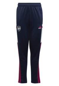 Pantalones deportivos azul marino con franjas laterales blancas y rosas, logo de Adidas en la cadera, logo del Arsenal en el muslo, cinturilla elástica, textura suave.