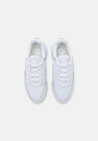 Valkoiset urheilukengät, joissa on verkkopäällinen, pyöreä varvas, pehmustettu nilkkaosa ja nauhakiinnitys. Minimalistiset yksityiskohdat ja hyllykkön muotoilu.