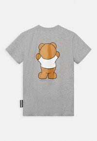 Šedé tričko s krátkým rukávem s velkým grafickým potiskem hnědého medvídka v bílém tričku na zadní straně a značkovou visačkou Moschino na boku.