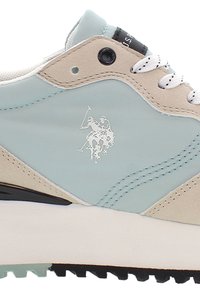 Jasnoniebieskie sneakersy z beżowymi akcentami, z teksturowaną cholewką, białymi sznurówkami, czarnymi elementami metalowymi i logo gracza polo z boku.