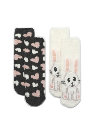 Due paia di calzini: uno nero con motivi a cuore rosa e bianco, e l'altro bianco con un design di un coniglio dei cartoni animati, morbido e peluso.