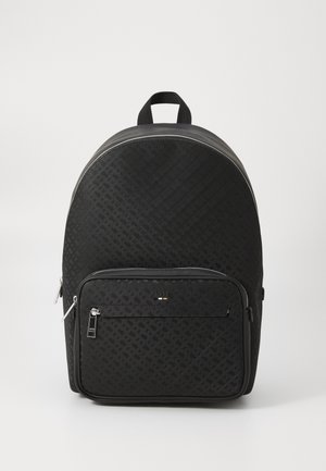 Sac à dos synthétique noir avec un motif texturé, forme arrondie, poche zippée à l'avant et une poignée en sangle en haut. Accents en métal argenté.