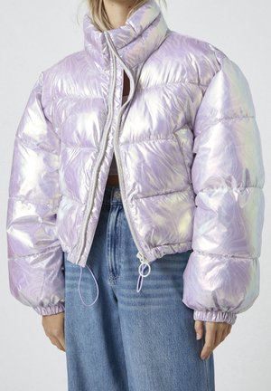 Opalizująca lawendowa kurtka puchowa z wysokim kołnierzem, pełnym zamkiem błyskawicznym i elastycznymi mankietami, noszona na osobie, na niebieskich, wysokowzwiązanych jeansach.