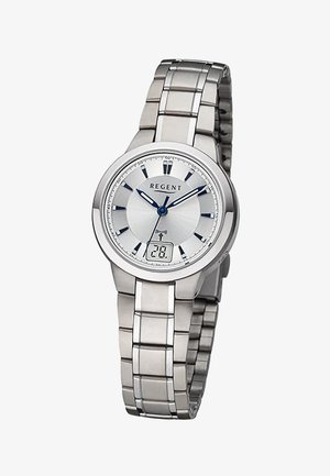 Montre-bracelet en métal argenté avec aiguilles analogiques bleues, index horaires noirs et affichage numérique de la date indiquant "28" à la position 6 heures.