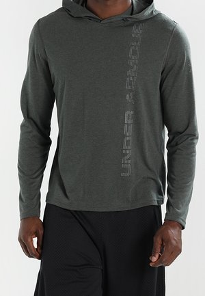 Zielony, długi rękaw z kapturem wykonany z miękkiej tkaniny, z pionowym wzorem refleksyjnego napisu po lewej stronie.