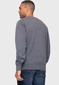 Grauer Langarm-Sweatshirt mit bequemer Passform. Verfügt über einen Rundhalsausschnitt, gerippte Bündchen und einen gerippten Saum, hergestellt aus einem weichen, strukturierten Stoff.