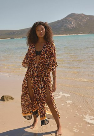 Kimono stil pokrivač s leopard uzorkom izrađen od lagane tkanine, s širokim rukavima, dubokim bočnim prorezima i kontrastnim crnim rubom.