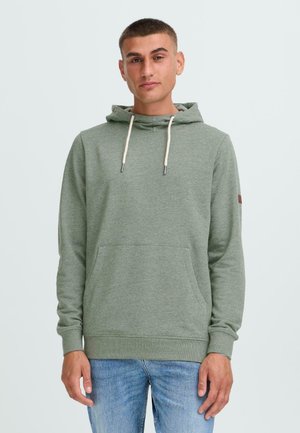 Green pullover hoodie made of soft fabric, featuring a kangaroo pocket, drawstring hood, and ribbed cuffs. Plain design with no visible patterns.