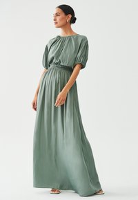 Maxime dress in vaaleanvihreä silkki, jossa on koottu toppi ja lyhyet pullotaskut, elastinen vyötärö ja valuva siluetti.