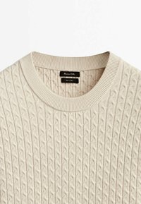 Beige gestrickter Pullover mit einem strukturierten Zopfmuster, einem gerippten Kragen und einem Markenlabel mit der Aufschrift "Massimo Dutti."