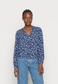 Blusa azul-marinho floral com mangas longas, decote em V e fecho com botão. Apresenta pequenas flores brancas e rosas numa tela texturizada.