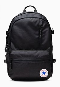 Mochila de tela negra con múltiples compartimentos con cremallera, espalda acolchada, asa en la parte superior y un parche redondo "Converse All Star".