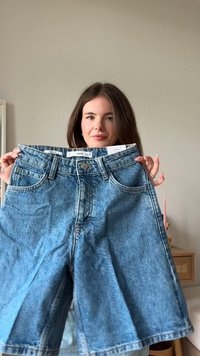 Denim-Shorts in Hellblau mit klassischem Fünf-Taschen-Design, raw hem und Knopfverschluss. Der Stoff wirkt leicht ausgebleicht und strukturiert.