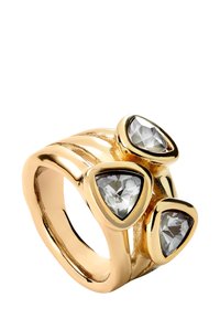 Bague en or avec un design de bande ondulée, comportant trois pierres grises triangulaires, montées dans des sertissages, présentant une finition métallique poli.