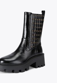 Czarne skórzane botki za kostkę z grubą platformą, z teksturowaną wstawką ozdobioną złotymi, sercami w kształcie ćwieków.