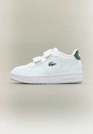 Baskets blanches Lacoste avec logo vert, deux sangles velcro et semelle de marque, présentées de profil sur fond neutre.