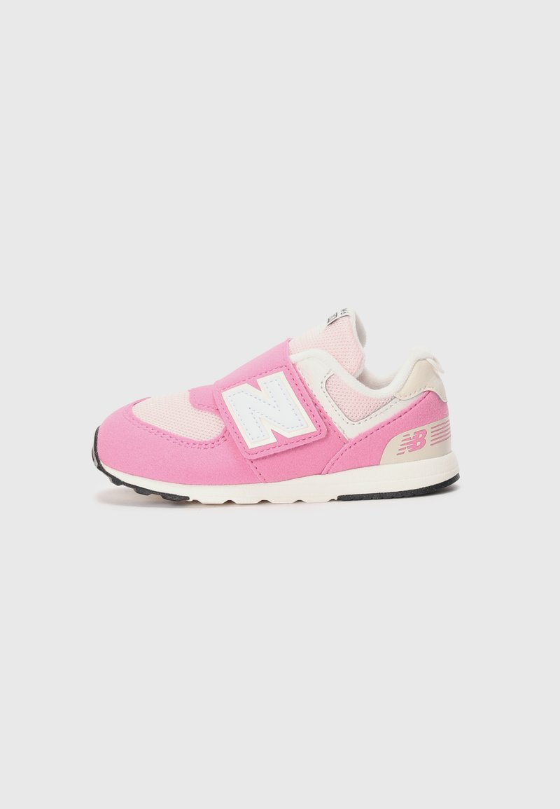 Zapatilla para bebés New Balance en rosa y blanco con correa de velcro, parte superior de malla y suela negra sobre un fondo claro y liso.