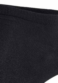 Svart ankelsocka med ribbat mönster och sömlös design, med ett elastiskt kant för en tajt passform. Lättviktsmaterial.