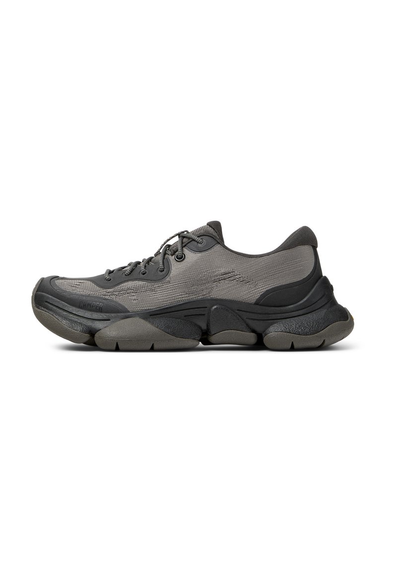 Graue Sportschuh mit einem Obermaterial aus Mesh, gepolstertem Kragen, dicker Sohle und strukturierten Akzenten. Verfügt über runde Schnürsenkel und ein rundes Zehendesign.