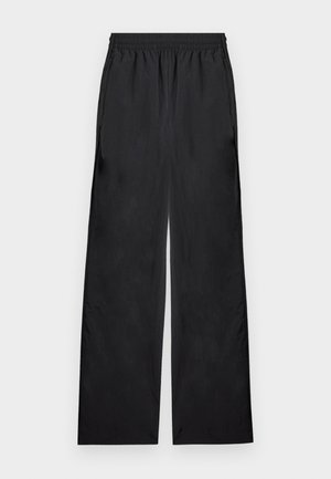 Pantalon large à taille élastique noire avec poches latérales, fabriqué en tissu léger, présenté sur un fond uni.