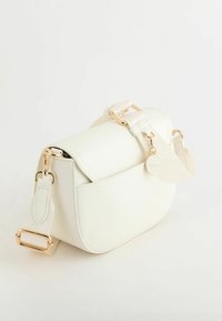 Hvid crossbody taske lavet af tekstureret materiale, prydet med guldfarvet hardware, flaplukning og en justerbar rem med et mærketag.