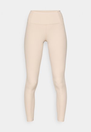 Beżowe ribbed legginsy z wysokim stanem. Charakteryzują się gładką teksturą i dopasowanym krojem, bez widocznych szwów lub logo.