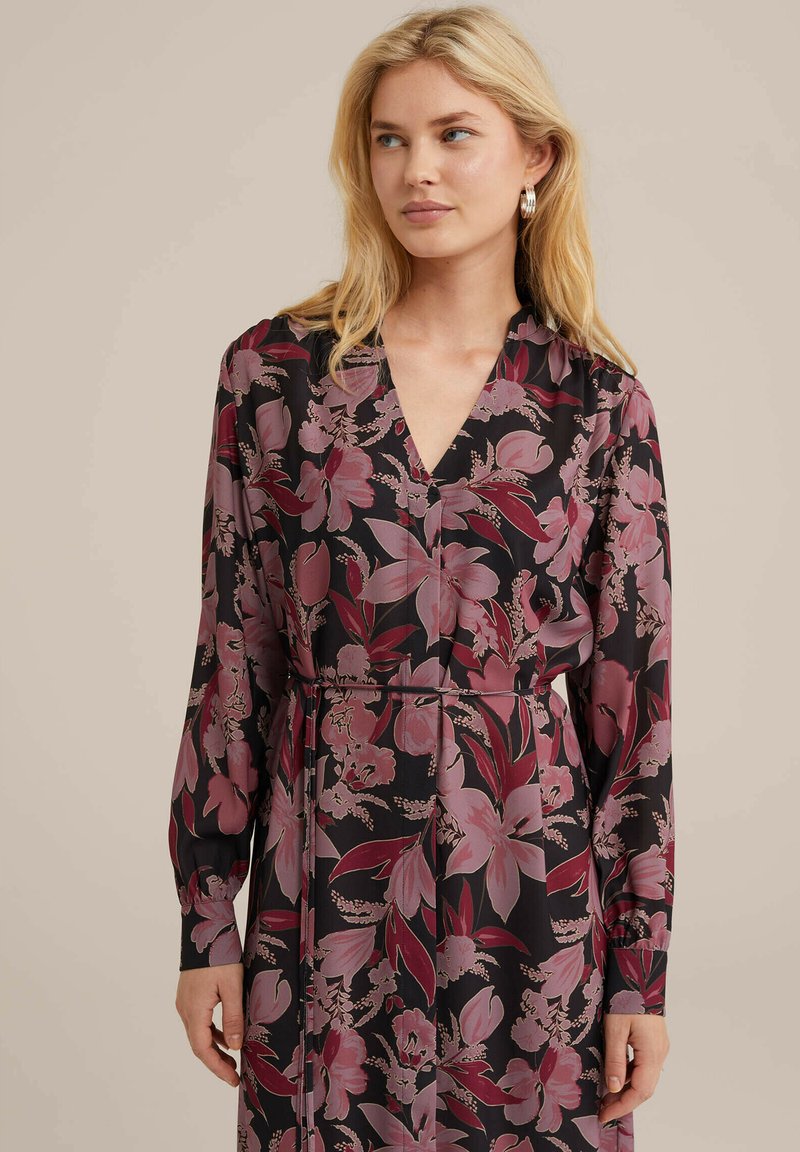 Schwarzes Blumenkleid mit großen rosa und burgunderfarbenen Blumen, langen Ärmeln, einem V-Ausschnitt und einer taillierten Silhouette mit einem Gürteldetail.