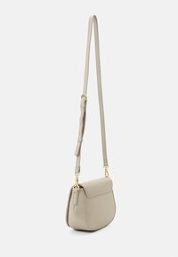 Borsa a spalla beige chiaro con patta frontale, tracolla regolabile e dettagli in metallo dorato. Realizzata in materiale sintetico liscio, forma curva.