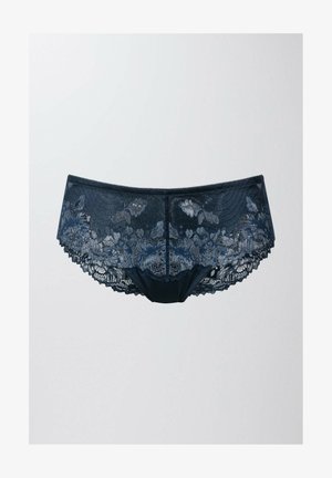 Kantbroek in een donker marineblauwe kleur met bloemmotieven, gegolfde randen en een zachte stofmix voor comfort.