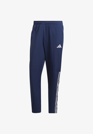 Granatowe spodnie dresowe wykonane z lekkiego materiału, z elastycznym pasem, białymi bocznymi paskami i logo Adidas na lewej udzie.
