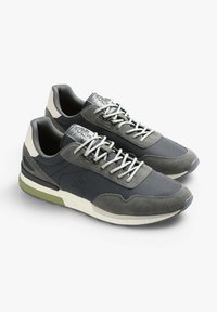 Sneakers da uomo con una combinazione di mesh grigio scuro e suede, dotati di suola in gomma. Dettagli notevoli includono lacci grigio chiaro e un logo a fantasia.