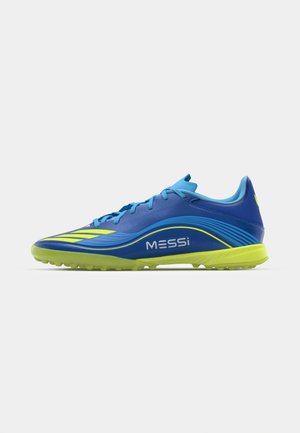 Le scarpe da calcio blu e verdi presentano una parte superiore testurizzata, accenti gialli, un design a profilo ridotto e una suola in gomma con chiodini per la trazione.