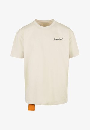 Cremefarbene Baumwoll-T-Shirt mit kurzen Ärmeln, geripptem Rundhalsausschnitt und schwarzem Text "vergessene Gesichter" auf der Brust. Mit einem oranges Etikett am Saum.