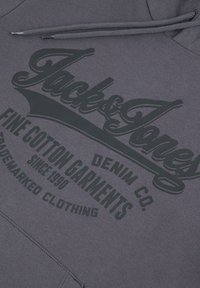 Sweat à capuche en coton gris avec un grand logo noir imprimé affichant les textes "Jack & Jones" et "Fine Cotton Garments". Comprend des cordons de serrage.