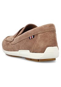 Braune Wildleder-Pantoletten mit einem niedrigen Absatz, weißer Gummisohle und kleinen dreifarbigen Akzenten an der Seite. Glatte Textur und lässiges Design.