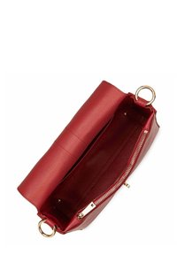 Borsa a mano in pelle rossa testurizzata, vista aperta che mostra la cerniera dorata, la tasca interna e l'anello di metallo rotondo. Design fluido e strutturato.