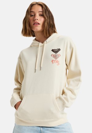Cream hooded sweatshirt with front pocket; features graphic design of hearts and “ROXY” in pink. Made of soft, textured fabric.