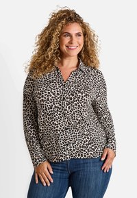 Blouse à boutons imprimé léopard en beige et marron, à manches longues avec un col. Tissu doux avec une texture lisse.