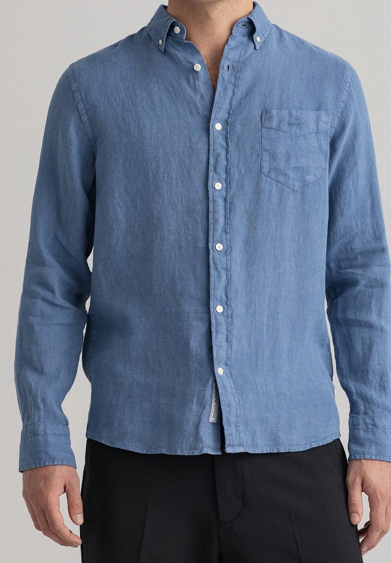 Camicia button-up azzurra chiara realizzata in tessuto morbido e testurizzato. Caratterizzata da colletto, maniche lunghe e una tasca sul petto con un dettaglio di etichetta tessuta.