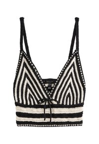 Häkelad bralette med svart och vit zigzag-mönster, justerbara remmar, texturerad yta och knytning framtill.