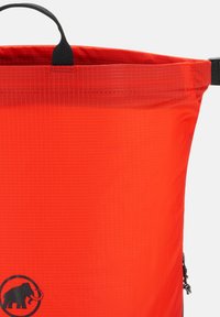 Sac à dos étanche rouge avec un motif de grille texturé, une poignée supérieure noire et un logo représentant un éléphant dans un design circulaire.