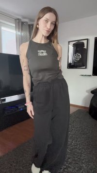 Juoda berankovė marškinėliai su grafiniu dizainu ir aukštu kaklu, derinami su plačiais juodais šortais. Minkšta tekstūra, kasdieniškas dizainas.