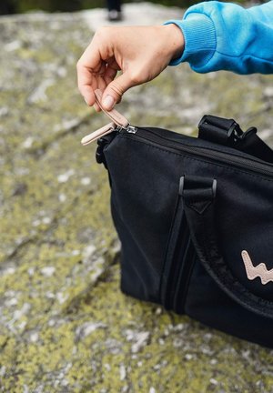 Černá taška s hladkým povrchem, s horním zipem a růžovým táhlem. Boční popruh a logo na přední straně v světle růžové barvě.