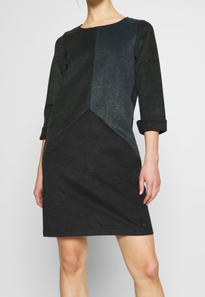 Dress with three-quarter sleeves, featuring a geometric design in dark green and black, made of soft, textured fabric.