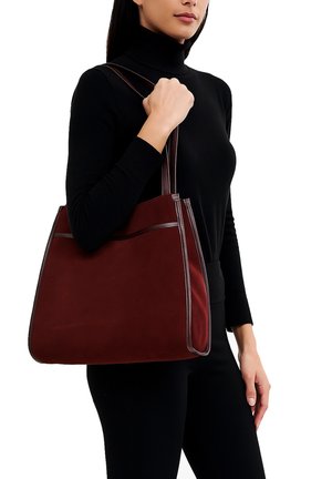 Borsa a spalla bordeaux con una superficie in suede liscia, bordatura in pelle a contrasto e doppio manico. Caratterizzata da una tasca frontale per lo stoccaggio.