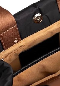 Interno di una borsa in tessuto marrone e nero con chiusura a scatto magnetico, tasca interna beige e scomparto con zip nera.