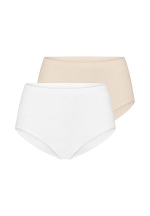 Woman with dark hair wearing a white bralette and high-waisted briefs, standing with arms crossed against a white background.