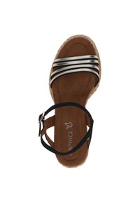 Hnědé espadrilky s černým řemínkem kolem kotníku, zdobené metalickými stříbrnými pruhy přes horní část a tkanou juteovou podrážkou. Hladký semišový povrch.